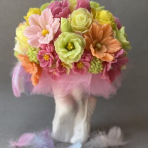 Handmade soap flower bouquet in pastel colours with pink tulle, displayed in a white ballet pointe shoe vase. Gift for ballerina or ballet teacher. Each flower is hand-poured from delicately scented soap, arranged in a sculpted pointe shoe vase made from high-quality plaster – a unique keepsake in itself.